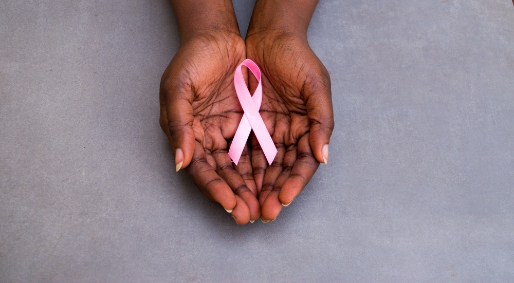 Hands holding a cancer ribbon