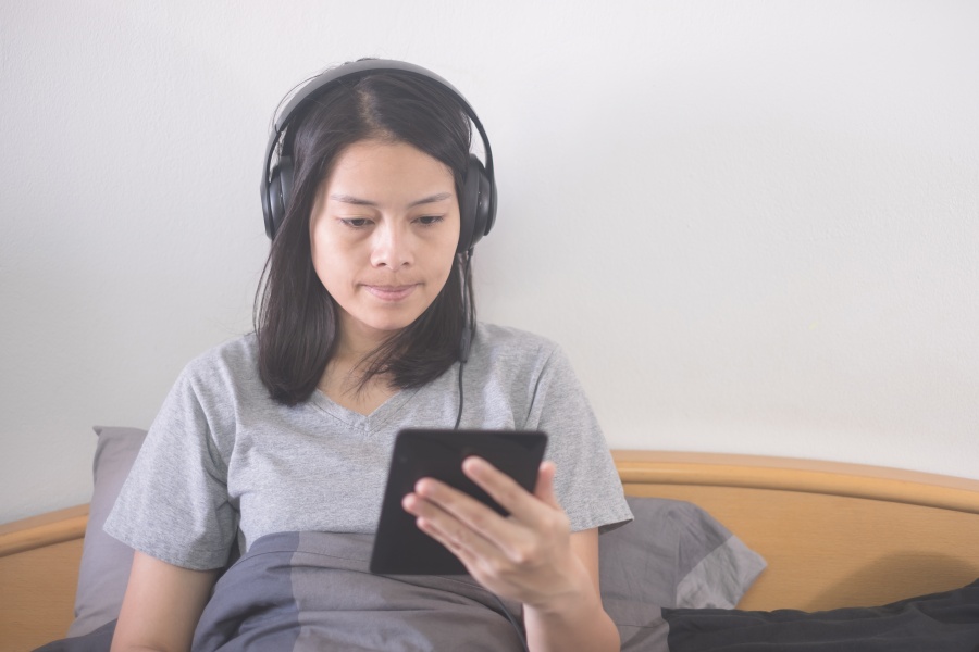 asian female watching autonomous sensory meridian response (ASMR) video